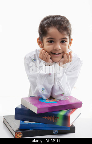 Girl s'appuyant sur une pile de livres Banque D'Images