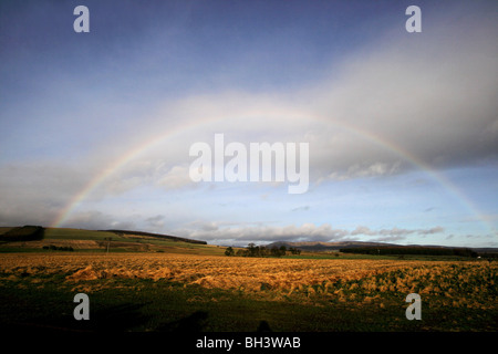 Arc en Ciel et nuages de tempête sur les terres agricoles et les collines dans l'Aberdeenshire. Banque D'Images