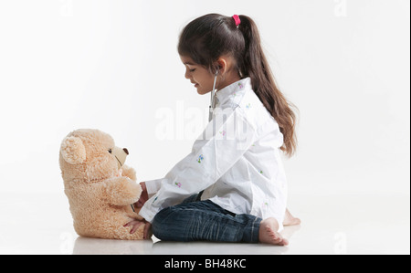 Girl playing doctor avec ours Banque D'Images