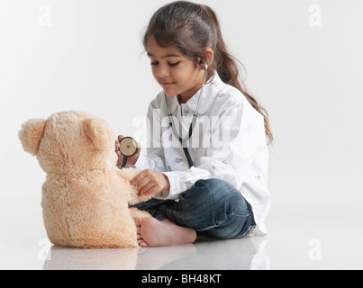 Girl playing doctor avec ours Banque D'Images