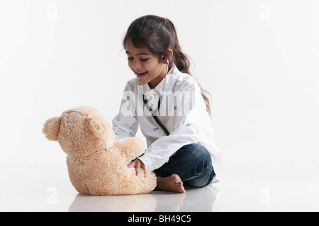 Girl playing doctor avec ours Banque D'Images