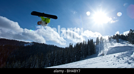 Un homme vole dans l'air après la planche au large de l'avance sur Teton Pass, le Wyoming. Banque D'Images