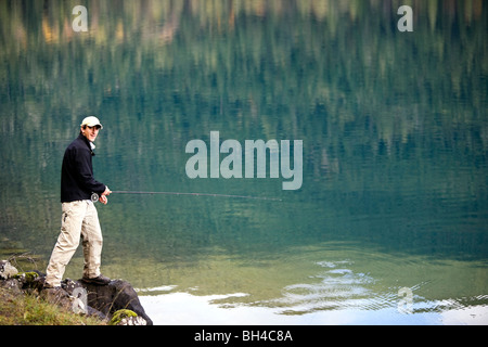 Un homme poissons mouche Lake Crescent à Washington's Olympic National Park. Banque D'Images