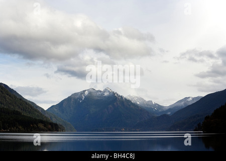 Encore une sous la neige du croissant du lac collines enneigées au loin, dans le Parc National Olympique de Washington. Banque D'Images