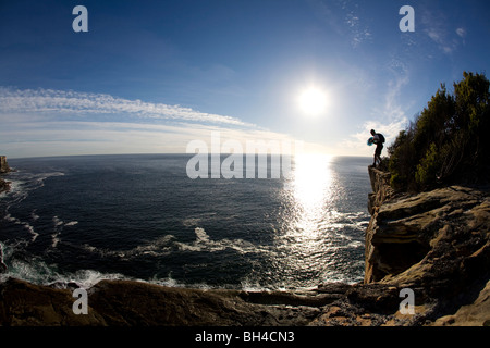 Un cavalier DE BASE vérifie les conditions avant de faire le saut d'une falaise à Sydney, Nouvelle-Galles du Sud, Australie. Banque D'Images