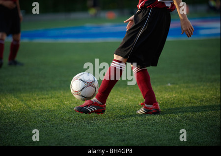 Young boy kicking ball avant match de football Banque D'Images