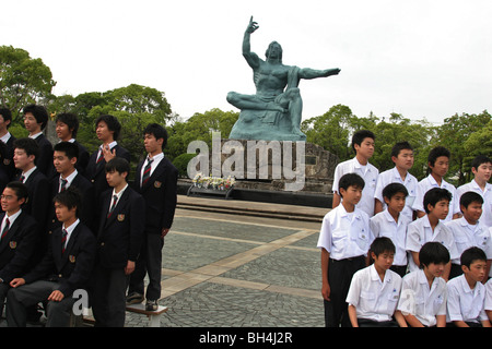 Les enfants de l'école se font photographier devant la sculpture de Seibo Kitamura 1955 à Nagasaki, Japon, Parc de la paix Banque D'Images