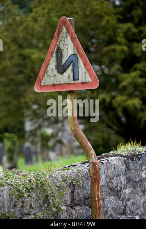 Chambre Double premier virage à gauche panneau routier. Crooked sign on post de travers. Pen-y-Dyffryn. Le Pays de Galles. United Kingdom. Banque D'Images