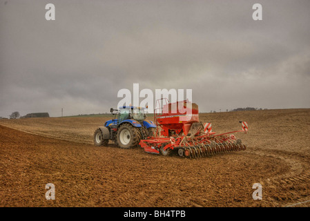 Riziculteur au travail grains semer sur sa terre avec un tracteur au printemps. Banque D'Images