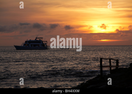 Bateau de croisière au coucher du soleil à la colline du Dragon, l'île de Santa Cruz. Banque D'Images