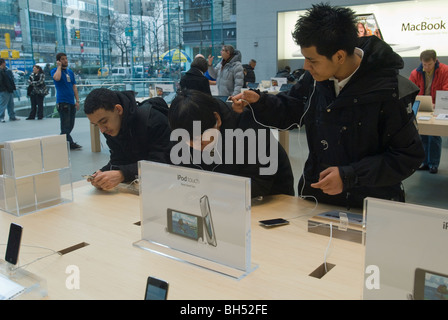 Les adolescents d'écouter de la musique sur iPod touch à l'Apple Store dans le quartier Upper West Side de New York Banque D'Images