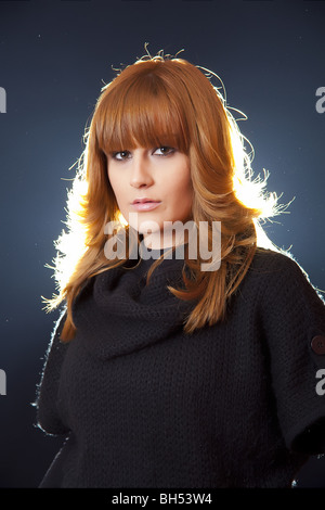 Dame en manteau noir sur fond sombre Banque D'Images