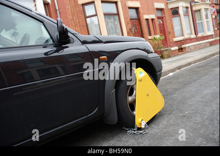 Pince munie d'une roue à une voiture par le DTAC pour une voiture sans un disque de taxe valide. En Angleterre, Royaume-Uni, Europe. Banque D'Images