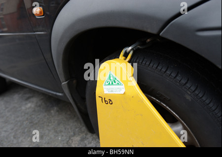 Pince munie d'une roue à une voiture par le DTAC pour une voiture sans un disque de taxe valide. En Angleterre, Royaume-Uni, Europe. Banque D'Images