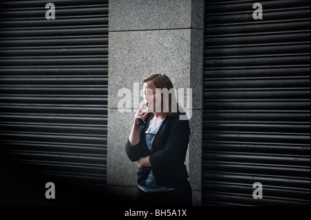 Une femme tire dur sur une cigarette off Talbot st. Dublin 1. Banque D'Images