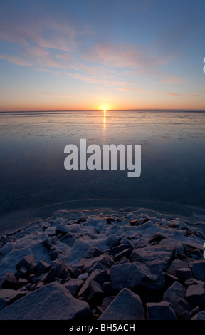 Derniers rayons de soleil reflétant de la glace de mer immaculée au coucher du soleil, Finlande Banque D'Images