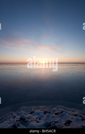 Derniers rayons de soleil reflétant de la nouvelle couche immaculée de glace de mer au coucher du soleil sur la mer Baltique , Golfe de Botnie , Finlande Banque D'Images