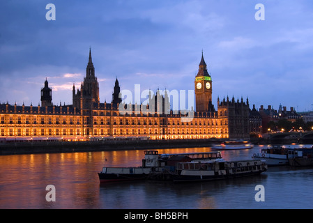 Chambres du Parlement et Big Ben avec des bateaux dans la Tamise par nuit Banque D'Images