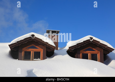 Deux lucarnes et d'un fumeur cheminée sur toiture de Maison Bavaroise en hiver, recouvert de neige. Photo par Willy Matheisl Banque D'Images