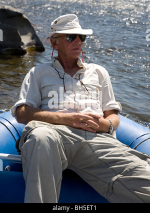 Homme plus âgé assis détendu en bateau gonflable Banque D'Images