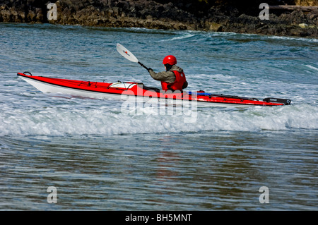 Les kayakistes de mer lumière négociation surfez sur la plage MacKenzie dans la région de Pacific Rim, Tofino, BC Banque D'Images