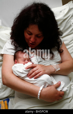 Nouvelle mère holding new born baby boy à l'hôpital peu après la naissance Banque D'Images