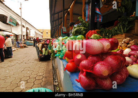 L'Équateur, Otavalo, close-up de légumes tomates mûres rouges et citron vert bleu emballées dans des packs de chaîne affichée sur un marché sta Banque D'Images