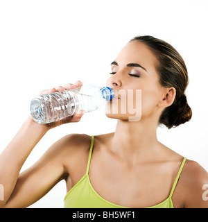 Belle brunette woman on white background boire de l'eau minérale dans une bouteille en plastique Banque D'Images