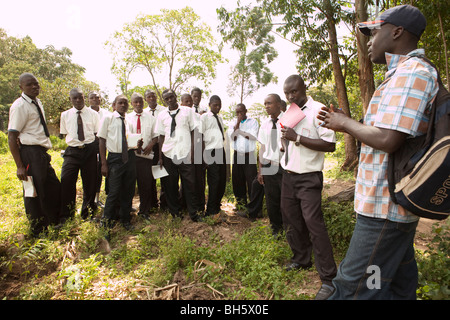 Élèves adolescents en savoir plus sur la préservation de l'environnement d'un garder ranger dans l'ouest du Kenya, près de la forêt de Kakamega réserver. Banque D'Images