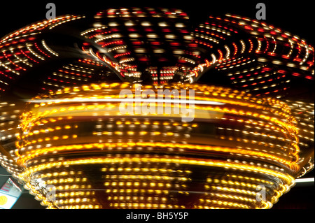 Lumières tourbillonnantes de manèges de carnaval de nuit. Banque D'Images