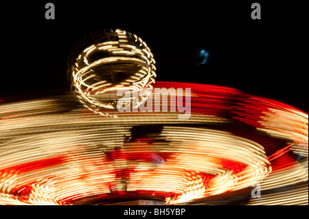 Lumières tourbillonnantes de manèges de carnaval de nuit. Banque D'Images