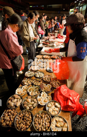 Les gens du shopping à Hong Kong's Bowrington Road marché humide de nuit. Banque D'Images