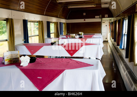 Les tables prévues, avec nappes de table mais sinon plutôt vide, dans un transport de voiture buffet polonais sur un train à destination de Cracovie. La Pologne. Banque D'Images