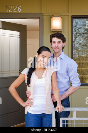 Couple sur porche avec sold sign Banque D'Images