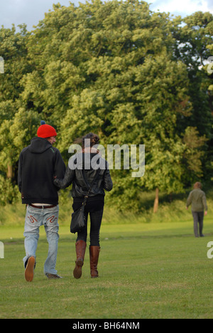 Un jeune couple en train de marcher dans un parc public de parler les uns aux autres. Banque D'Images