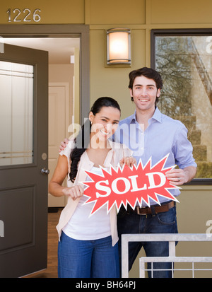 Couple sur porche avec sold sign Banque D'Images