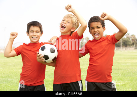 Les jeunes garçons dans l'équipe de football célèbre Banque D'Images