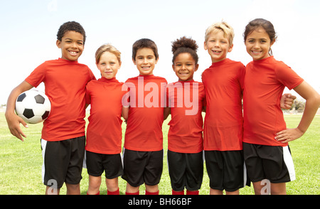 Les jeunes garçons et filles dans l'équipe de football Banque D'Images