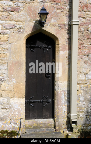 Sacristie porte dans une église avec l'ancien tuyau de Cotswold. Banque D'Images