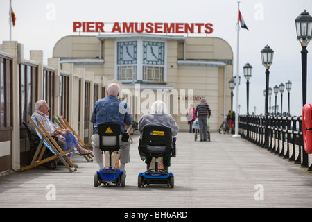 Pentioners sur la mobilité des scooters de route le long de la jetée d''Eastbourne. Photo par James Boardman Banque D'Images