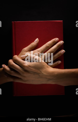 Hands holding book Banque D'Images