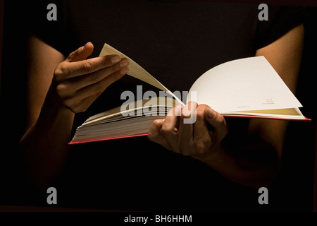 Hands holding book Banque D'Images