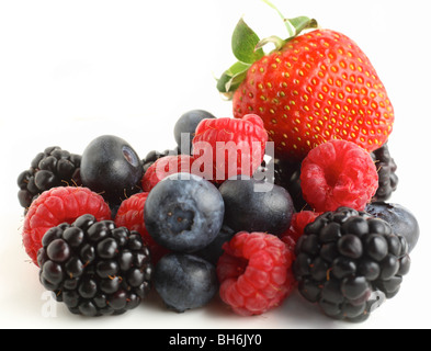 Une pile de baies, bleuets, framboises, mûres et une fraise, sur un fond blanc. Banque D'Images