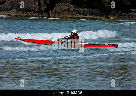 Les kayakistes de mer lumière négociation surfez sur la plage MacKenzie dans la région de Pacific Rim, Tofino, BC Banque D'Images