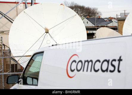 Comcast Corporation un logo sur un véhicule en face d'une antenne parabolique. Banque D'Images