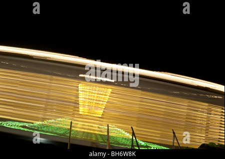 Lumières tourbillonnantes de manèges de carnaval de nuit. Banque D'Images