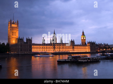 Chambres du Parlement et Big Ben avec des bateaux dans la Tamise par nuit Banque D'Images