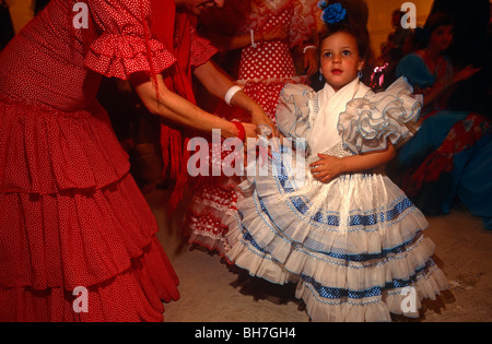 Une mère s'occupe de sa jeune fille flamenco-habillés dans une caseta (Chapiteau) au cours de la Feria de Séville au printemps. Banque D'Images