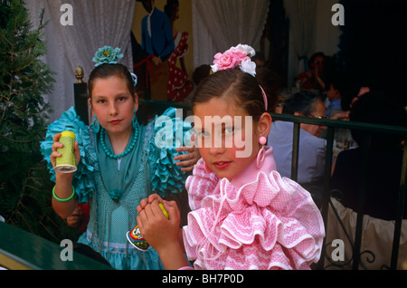 Deux jeunes sœurs flamenco habillé verre à l'extérieur d'une caseta (Chapiteau) au cours de la Feria de Séville au printemps. Banque D'Images