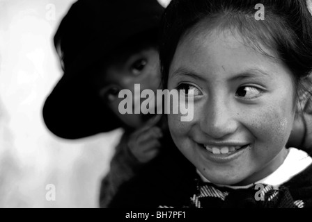 L'Équateur, Quito, close-up of a Girl avec ses grands yeux bruns lumineux et souriant, ses joues brûlées par le soleil, w/ baby sister Banque D'Images